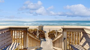A wooden boardwalk leading to a beach with a small structure in the middle. - Newly-renovated top-floor condo with a beach & Gulf view, lagoon pool, & hot tub (Miramar Beach)