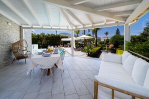 A covered patio with a dining table, chairs, and a white sofa. - Exclusive villa with swimming pool and spa (CASTELLAMMARE DEL GOLFO)