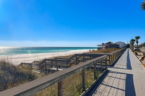 A wooden boardwalk leading to a beach with a clear view of the ocean and a building with a sloped roof. - Spacious villa with full kitchen, shared pool & beach access - pets and snowbirds welcome (Miramar Beach)
