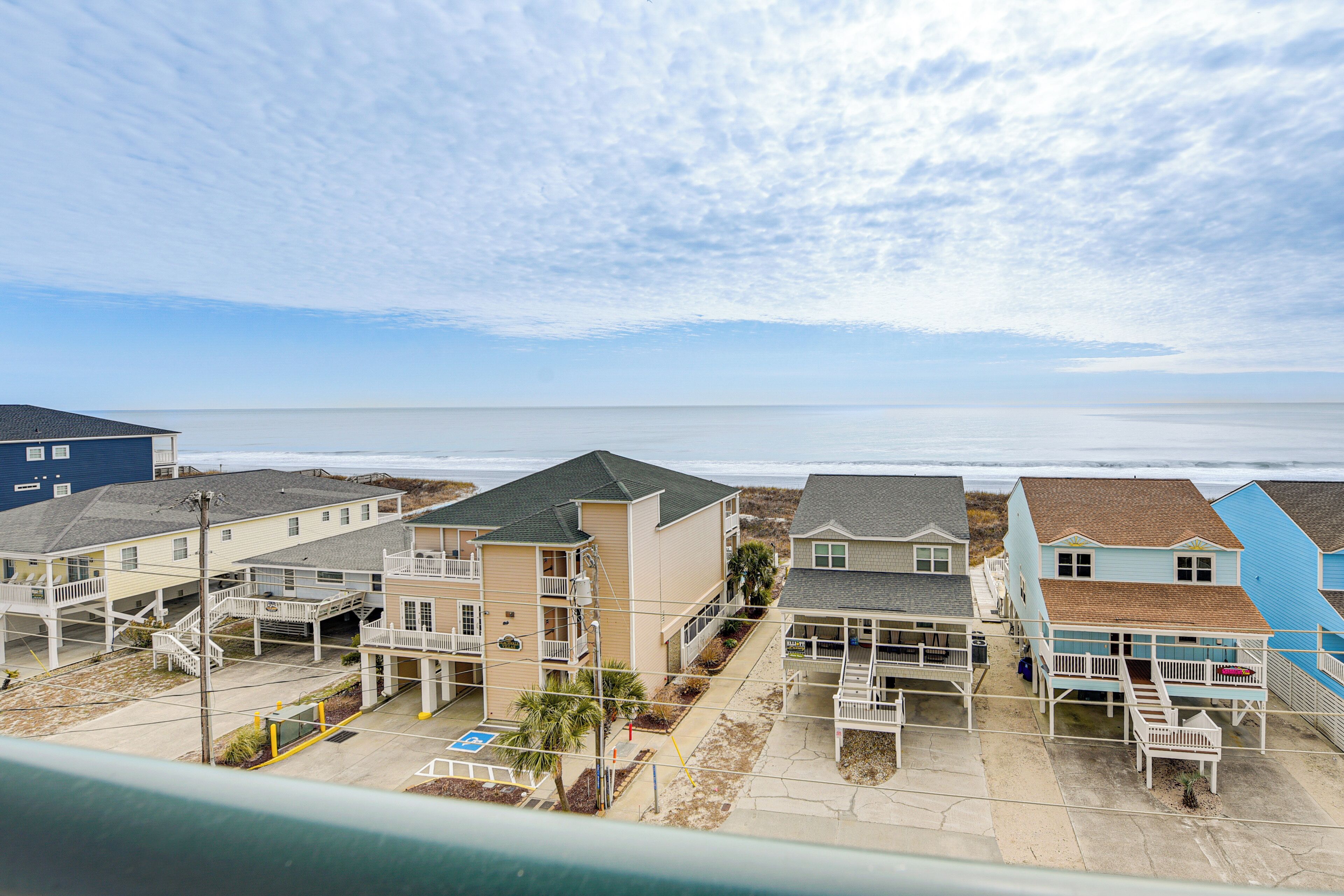 Um hotel à beira-mar com vários edifícios, varandas e vista para o oceano.