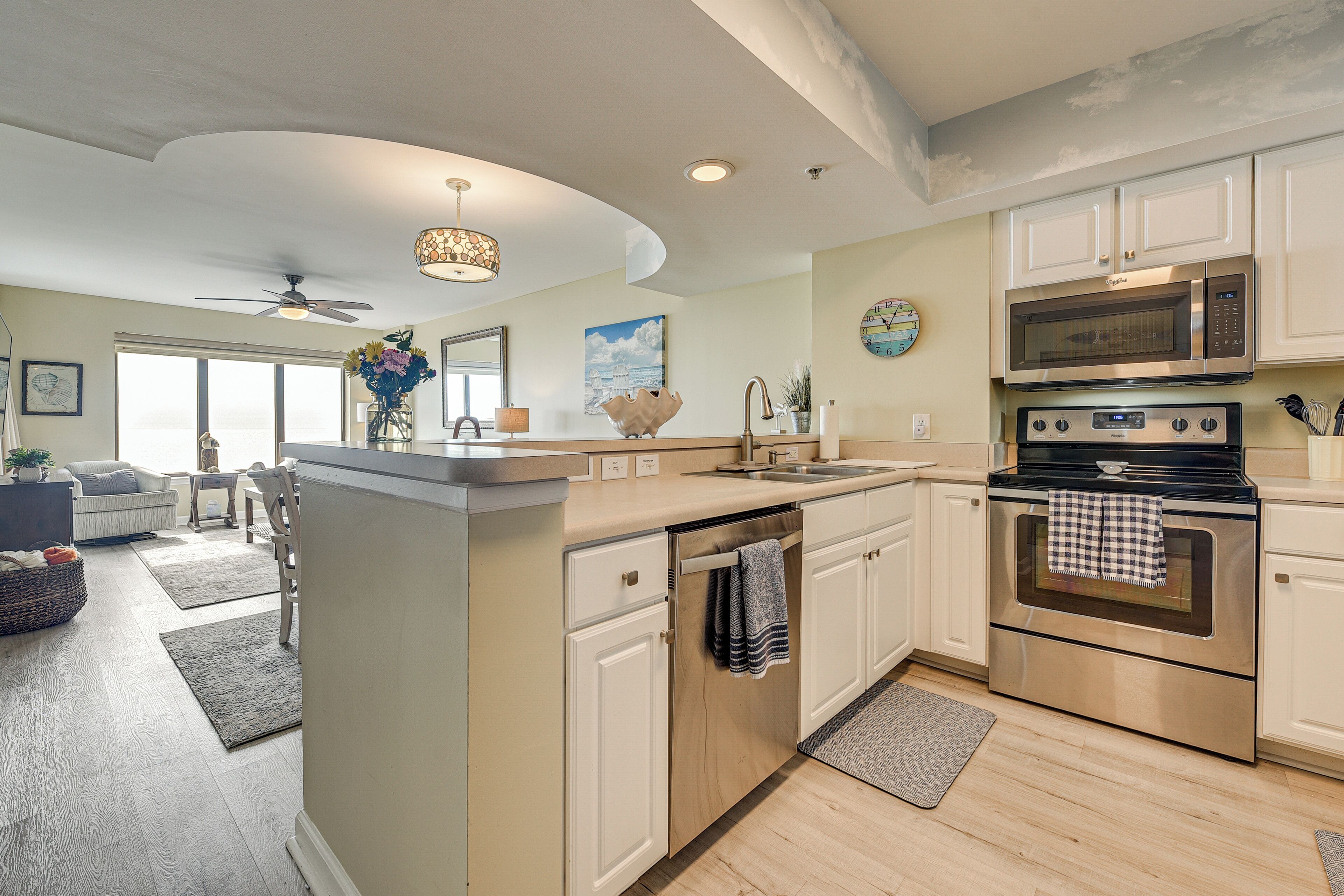 A modern kitchen with a central island, stainless steel appliances, and a dining area with a view.