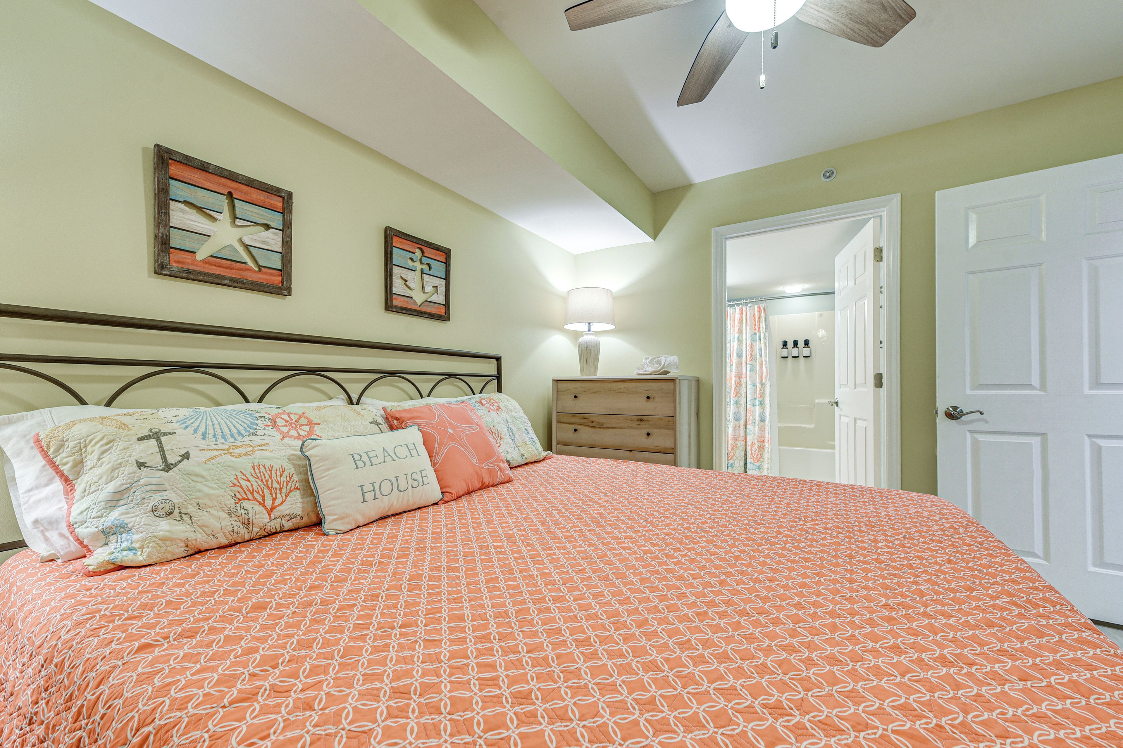 A bedroom with a bed, a nightstand, a dresser, and a ceiling fan.