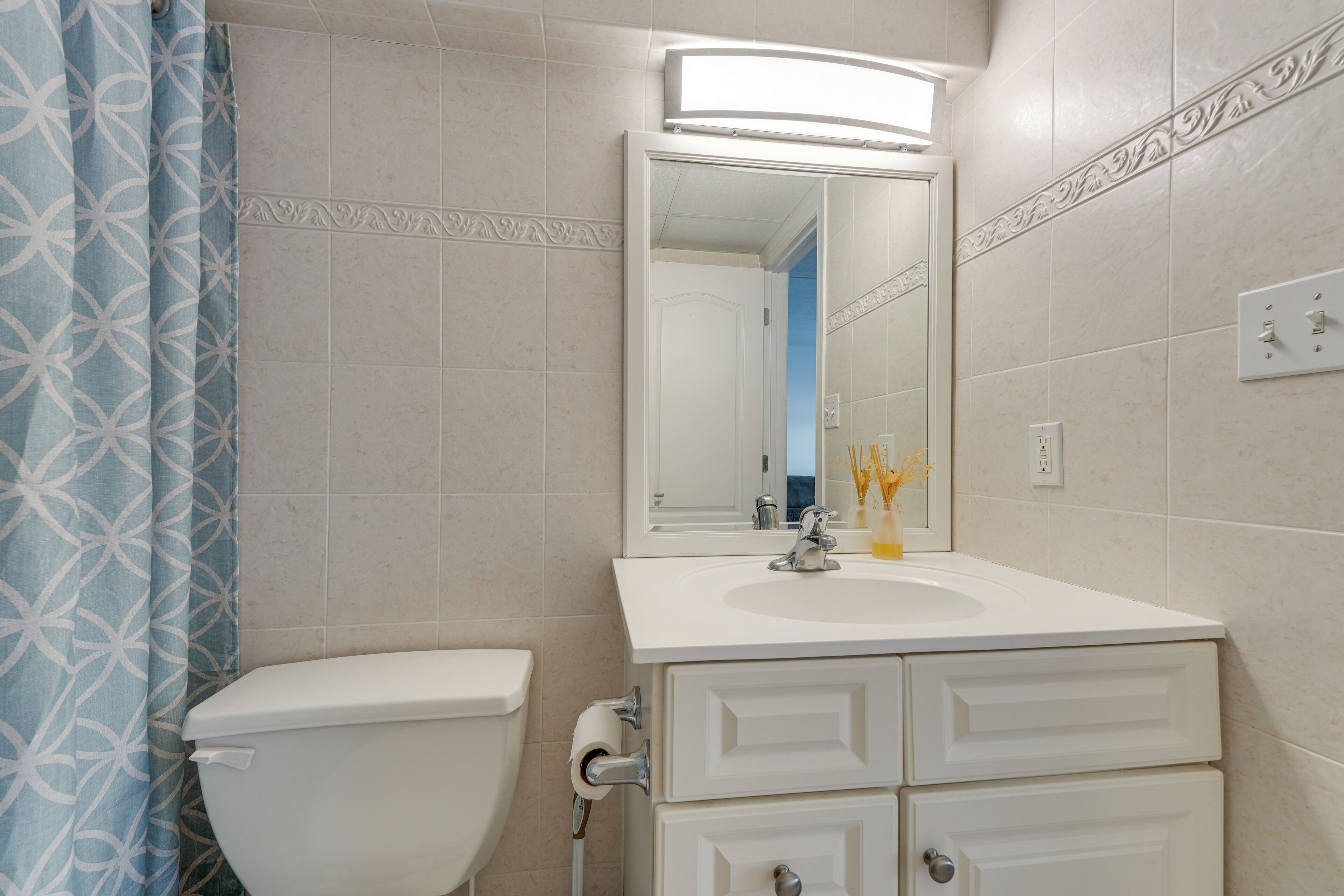 Une salle de bain avec des toilettes, un lavabo et un miroir.