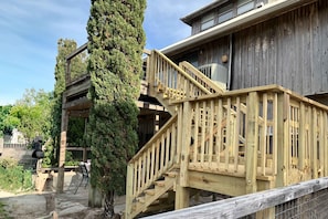 A wooden building with a wooden staircase leading to a balcony. - Coastal home with deck, screened porch, central AC, & washer&dryer - near beach (St. George Island)