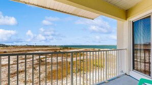 Ein Balkon mit Blick auf Strand und Meer.