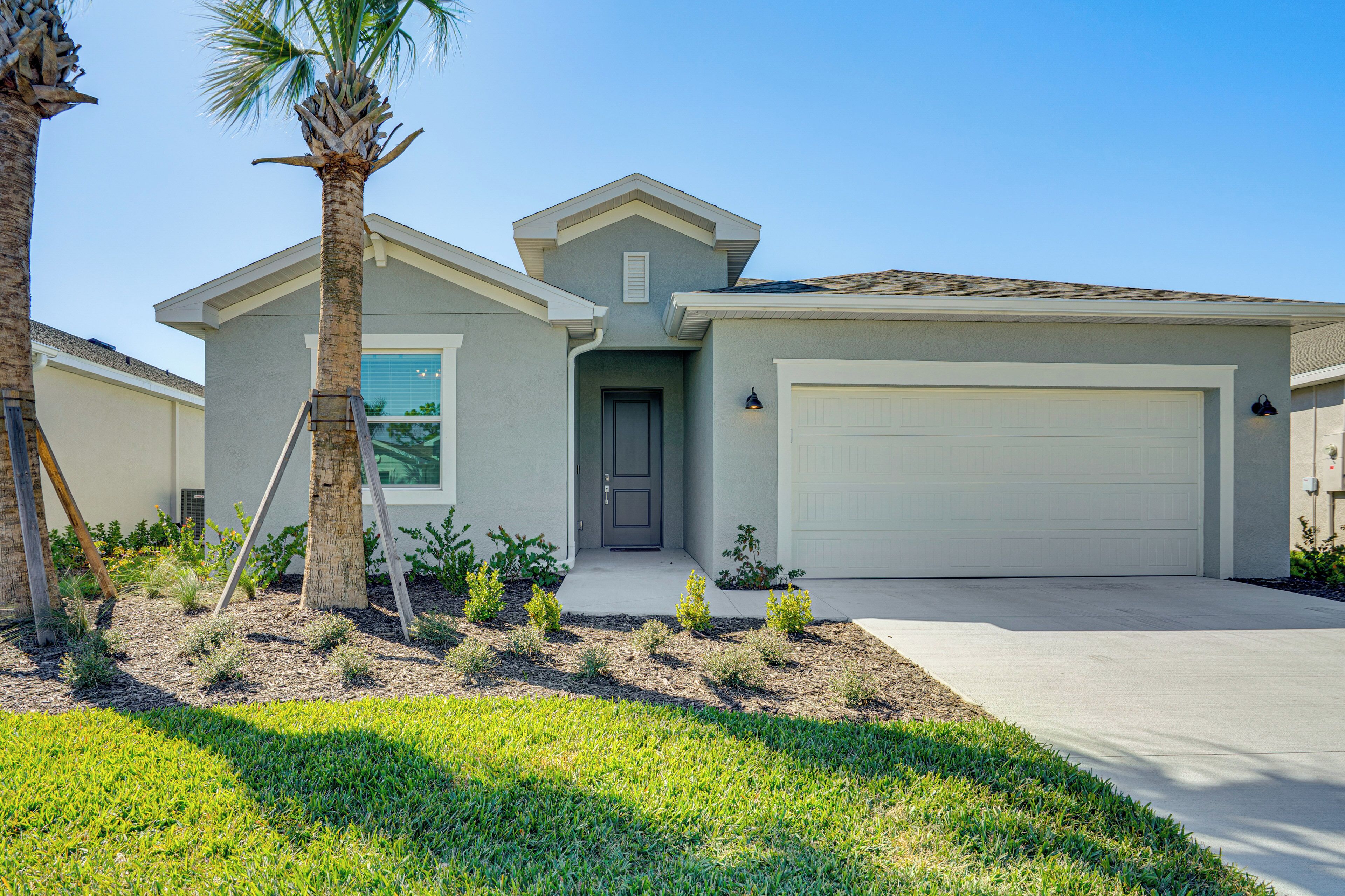 A single-story house with a garage, a front door, and a small porch area.