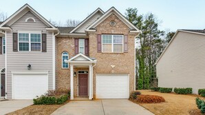 A two-story house with a front garage, a brick facade, and a symmetrical design. - Community Pool! East ATL Base Near Mercedes-benz (Atlanta)
