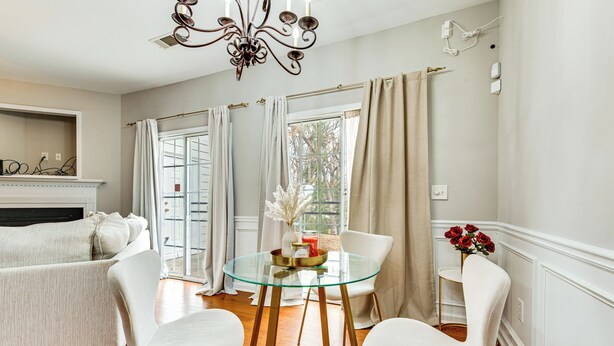 A modern living room with a glass coffee table, white chairs, a fireplace, and a view through large windows. - Community Pool! East ATL Base Near Mercedes-benz (Atlanta)