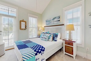 A bedroom with a bed, bedside tables, a nightstand, a window with blinds, and a wall-mounted mirror. - Coastal home with 2 community pools, bikes, front porch & balcony - near beach (Santa Rosa Beach)