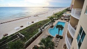 Et hotel ved stranden med pool, direkte adgang til stranden og en pier i baggrunden.