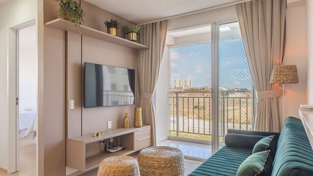 A modern living room with a sofa, TV, and plants on shelves. - Mirante #406 - Two Bedroom Apartment by Carpediem (Fortaleza)