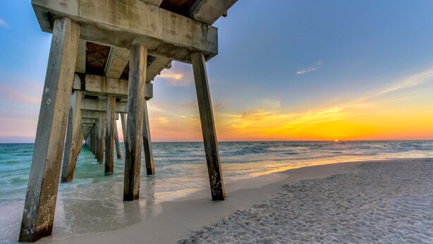 A beach with a concrete pier extending into the ocean. - Gulf-front condo with beautiful sunset views, pool, tiki bar, fitness room & W&D (Panama City Beach)
