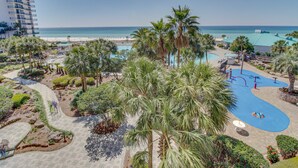 Ein Resort mit Poolbereich, Palmen und Blick auf den Strand.