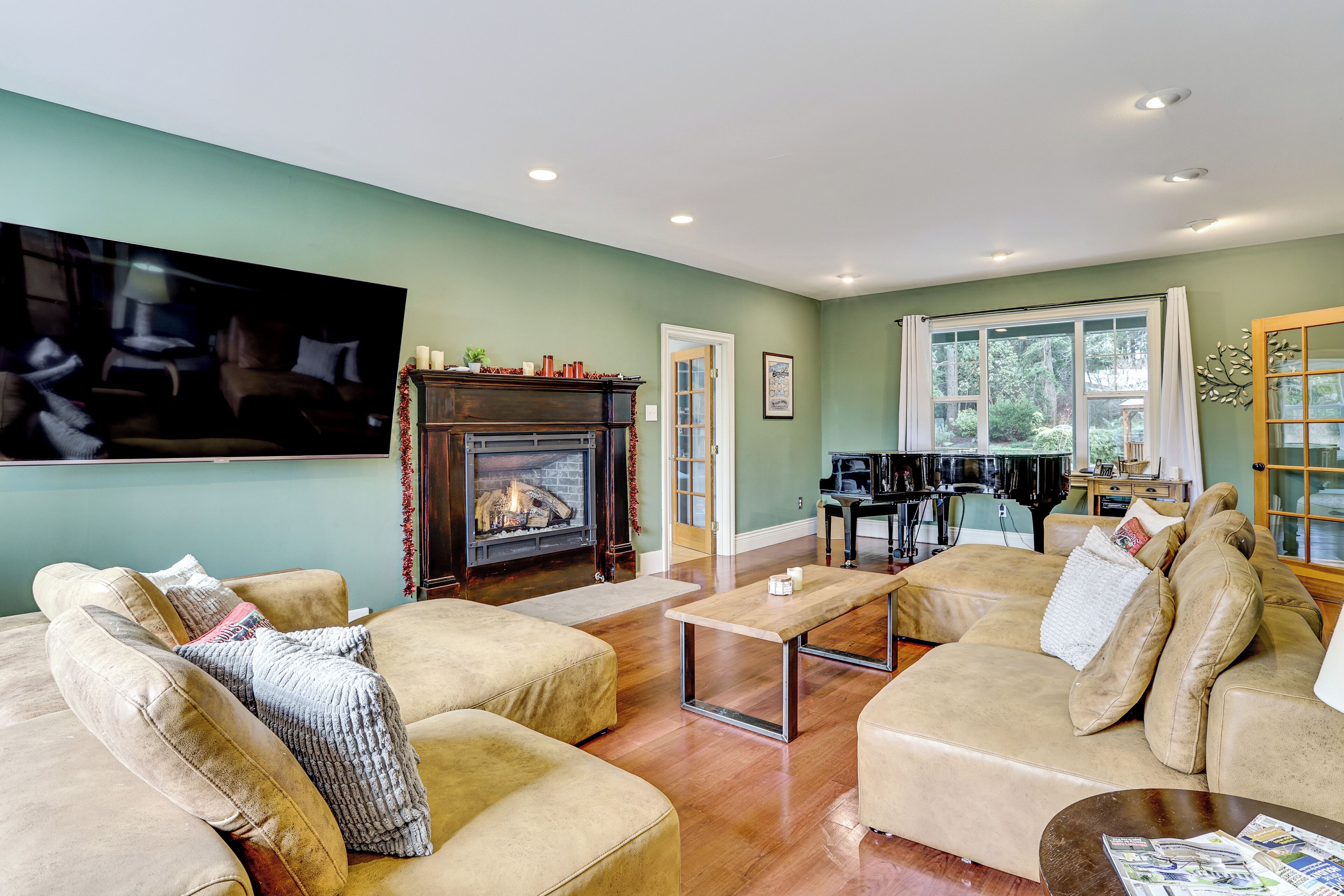 A living room with a fireplace, sofas, a coffee table, and a television.
