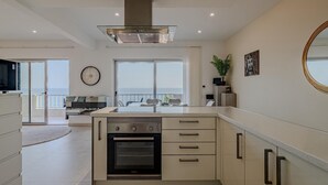 Uma cozinha moderna com forno embutido, uma janela ampla com vista e uma área de jantar também com vista.