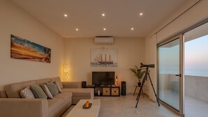 Uma sala de estar moderna com um sofá, uma mesa de centro, uma televisão e um telescópio.