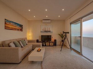 Ein modernes Wohnzimmer mit einer Couch, einem Couchtisch, einem Fernseher und einem Teleskop.