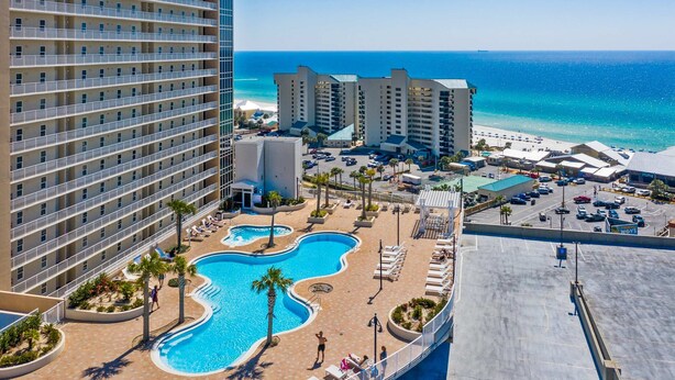 Un hôtel doté d’une piscine, de plusieurs étages et offrant une vue sur la plage et l’océan.