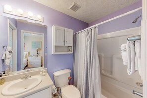 Een badkamer met een wastafel, toilet en bad.