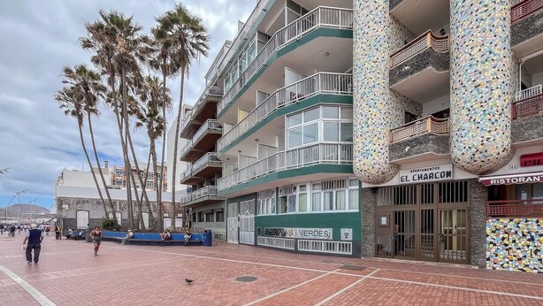 A multi-story building with balconies, a mosaic column, and a sign for 'APARTAMENTOS CHARCON'. - Estudio en primera línea de playa (Las Palmas de Gran Canaria)