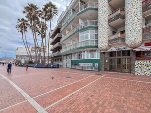 A multi-story building with balconies, a mosaic column, and a sign for 'APARTAMENTOS CHARCON'. - Estudio en primera línea de playa (Las Palmas de Gran Canaria)