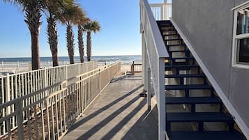 A staircase leading to a building with a view of the ocean.