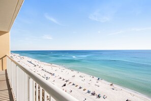 A beach with clear turquoise water, white sand, and a balcony overlooking the scene. - Beachfront condo on 10th floor w/shared pools (4), hot tub, tennis - great views (Panama City Beach)