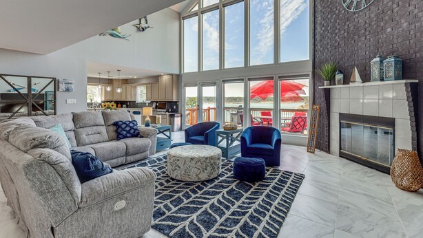 Een ruime woonkamer met een groot raam, een open haard en moderne meubels.