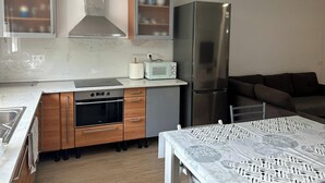 A modern kitchen with a stainless steel refrigerator, a built-in oven, and a microwave on the countertop. - Las Tabaibas beach house (San Bartolomé de Tirajana)