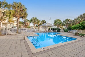 A swimming pool with a 3 ft depth marker, surrounded by palm trees and a covered seating area. - Gulf view condo with central AC, WiFi, washer&dryer, & pool - walk to beach (Navarre Beach)