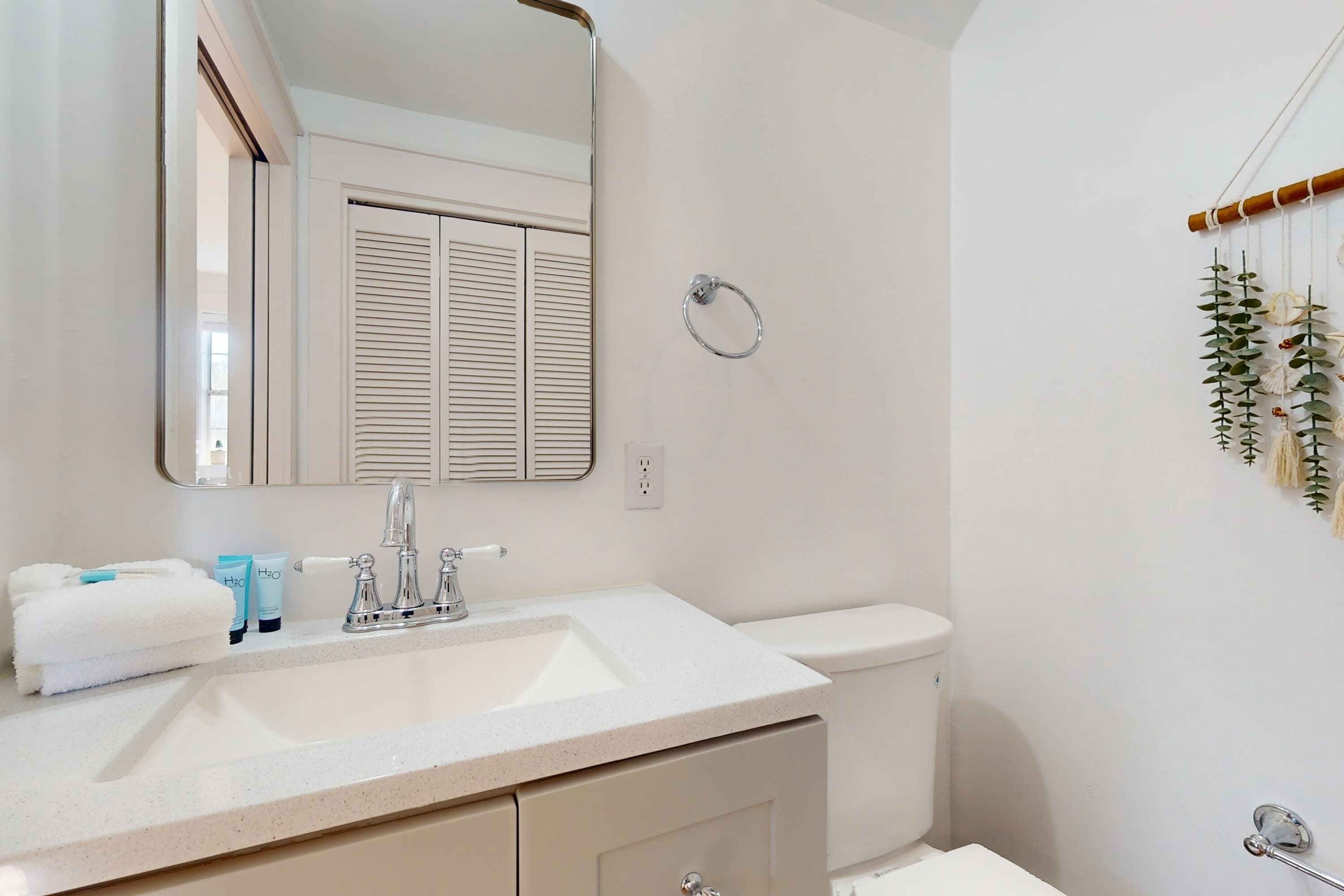 Ein Badezimmer mit Waschbecken, Spiegel und Toilette.