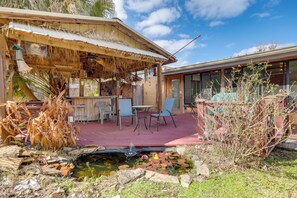 A patio area with a small pond, chairs, and a table.