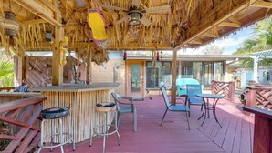 An outdoor patio area with a wooden deck, a bar with stools, and a ceiling fan. - Sunroom & Spacious Yard! Family Gem in Orange Park (Orange Park)
