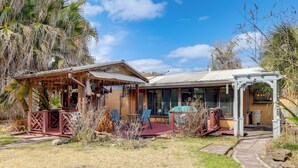 A house with a covered porch, outdoor seating, and a garden area. - Sunroom & Spacious Yard! Family Gem in Orange Park (Orange Park)