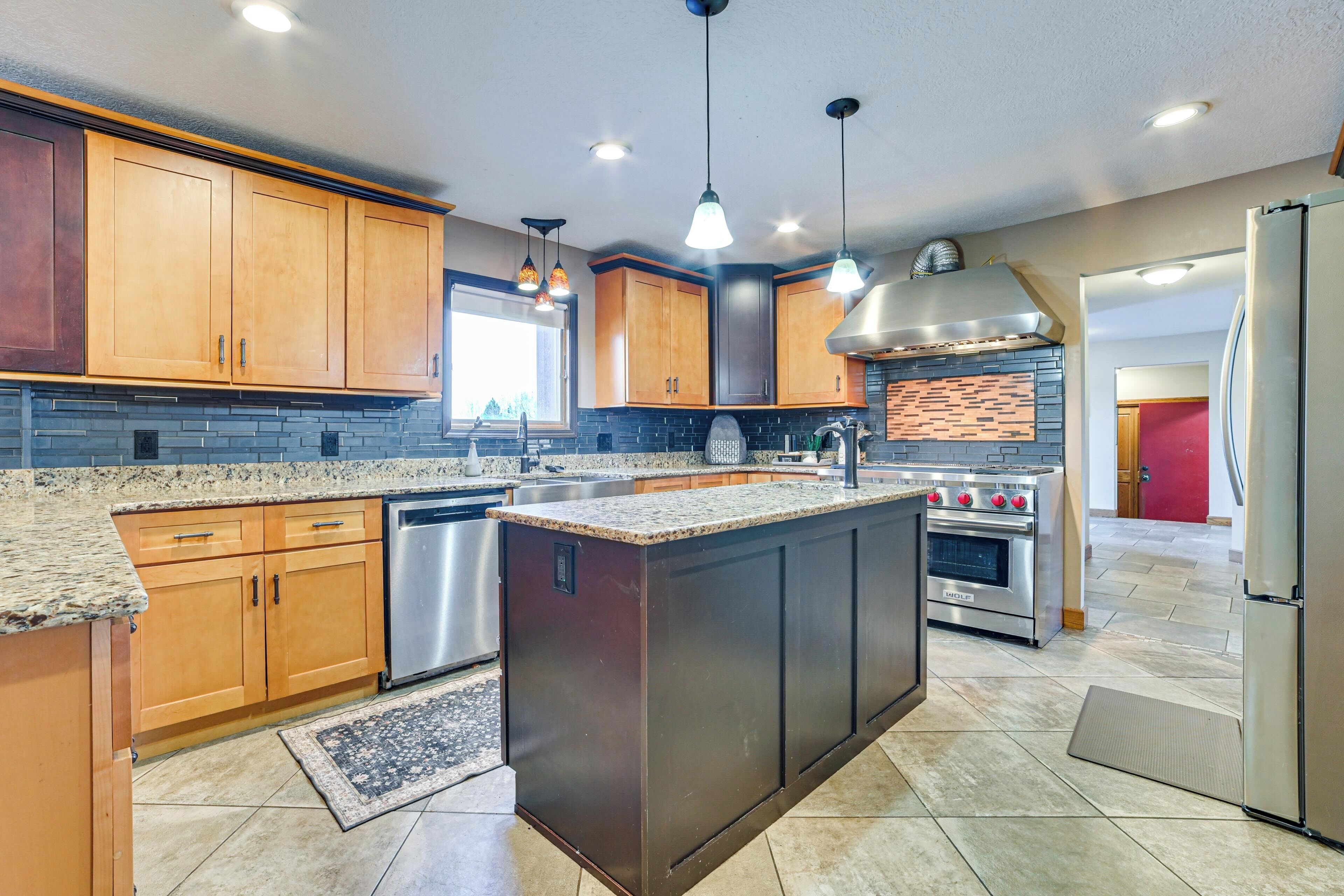 A modern kitchen with granite countertops, stainless steel appliances, and wooden cabinets.