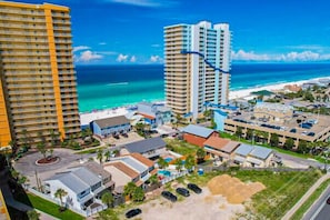 Ein Küstenhotel mit mehreren Hochhäusern, einem Strand und einem Parkplatz.