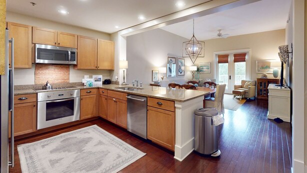 A modern kitchen with wooden cabinets, stainless steel appliances, and a central island.