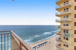 A beachfront hotel with balconies overlooking the ocean, a sandy beach, and a clear sky. - Stylish beachfront condo in West Tower with water views, pool/hot tub & W/D (Panama City Beach)
