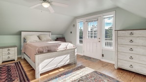 A bedroom with a bed, a dresser, a ceiling fan, and a door leading outside. - Northern Neck Nature Retreat w/ Boat Ramp & Dock! (Heathsville)