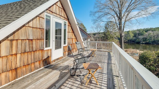 A wooden deck with outdoor furniture, a white railing, and a view of a lake. - Northern Neck Nature Retreat w/ Boat Ramp & Dock! (Heathsville)