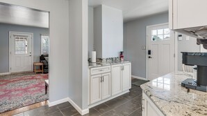 A modern kitchen with white cabinets, a granite countertop, and a built-in oven. - Northern Neck Nature Retreat w/ Boat Ramp & Dock! (Heathsville)
