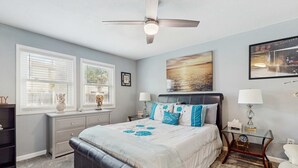 A bedroom with a bed, a ceiling fan, a nightstand, and a window with blinds. - Coastal Townhouse with WiFi, Central AC, and Shared Pool (Navarre)