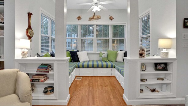A room with a large window, a ceiling fan, and a bed with striped bedding. - Centrally located home with enclosed yard, grill, high ceilings, smart TVs, & AC (Santa Rosa Beach)
