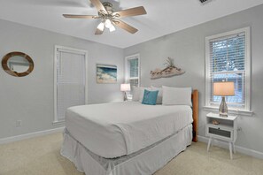 A bedroom with a bed, a ceiling fan, a nightstand with a lamp, and a window with blinds. - Centrally located home with enclosed yard, grill, high ceilings, smart TVs, & AC (Santa Rosa Beach)