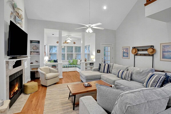 A living room with a fireplace, a sofa set, a coffee table, and a television. - Centrally located home with enclosed yard, grill, high ceilings, smart TVs, & AC (Santa Rosa Beach)