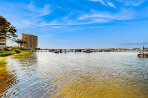 Une vue sur le front de mer, avec un hôtel, une jetée et un ciel bleu dégagé.