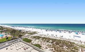A beach resort with a pool area, beach umbrellas, and a sandy beach. - 6th Floor Condo, On-site restaurant & bar, Splash pad w pool (Destin)