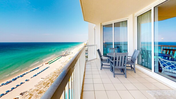 Un balcon avec vue sur une plage et l’océan.