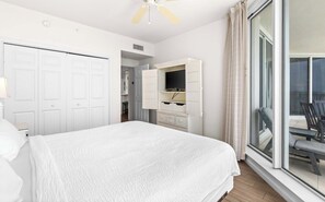 A bedroom with a bed, a wardrobe, a television, and a balcony with a chair. - Comfortable condo with Gulf-front balcony & on-site pool (Destin)
