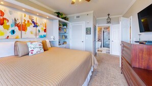 A bedroom with a bed, a ceiling fan, a TV, and a bookshelf. - Idyllic beach getaway w gulf views & swimming pool - beach access (Destin)